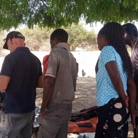 man preparing filming equipment in an African village