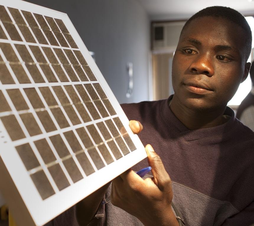 African man holding small solar panel