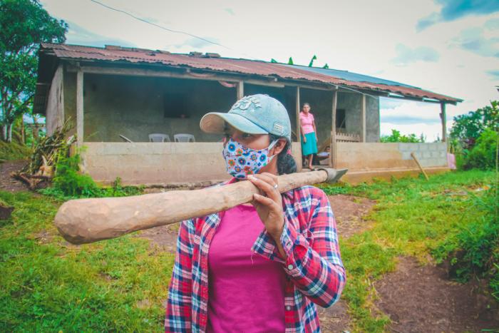 A woman farmer carries tools in Nicaragua